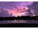 Scenic purple sunset view over the water with vibrant pink and purple hues reflecting on the clouds at 11127 Hudson Hills Ln, Riverview, FL 33579