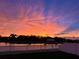 Scenic sunset view over the water with vibrant orange, pink, and purple hues reflecting on the clouds at 11127 Hudson Hills Ln, Riverview, FL 33579