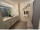 Bathroom with dual sinks, and decorative accents including plants and framed artwork at 16949 Secret Meadow Dr, Odessa, FL 33556
