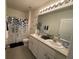 Bathroom featuring a dual sink vanity, large mirror with modern lighting, and a shower-tub combination at 16949 Secret Meadow Dr, Odessa, FL 33556