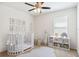 Cozy Bedroom with a white crib, animal-themed decor, and storage shelves for toys at 16949 Secret Meadow Dr, Odessa, FL 33556