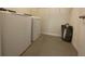 A laundry room featuring a washer, a dryer, and a laundry hamper on a tiled floor at 16949 Secret Meadow Dr, Odessa, FL 33556