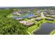 An aerial view of a home by a lake, nestled in a community surrounded by trees at 4899 Isola Ct, Wesley Chapel, FL 33543