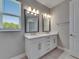 Bathroom featuring a white double sink vanity, modern lighting and neutral tile floors at 4899 Isola Ct, Wesley Chapel, FL 33543