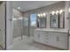 Bathroom featuring a glass-enclosed shower and a white double sink vanity at 4899 Isola Ct, Wesley Chapel, FL 33543