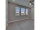 Bedroom featuring grey wood flooring, a ceiling fan, and three large windows at 4899 Isola Ct, Wesley Chapel, FL 33543