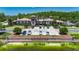 Clubhouse exterior with palm trees, well manicured lawns, landscaping, parking and a sign at 4899 Isola Ct, Wesley Chapel, FL 33543