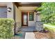 Inviting front porch with a red front door and stone accents creates a warm welcome at 4899 Isola Ct, Wesley Chapel, FL 33543