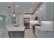 Bright kitchen boasts stainless steel appliances, white cabinetry, and a gray center island with pendant lighting at 4899 Isola Ct, Wesley Chapel, FL 33543