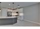 Stylish kitchen features an island with quartz countertops, pendant lighting, white cabinetry and stainless steel appliances at 4899 Isola Ct, Wesley Chapel, FL 33543