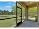 Screened-in lanai showing an expansive backyard view overlooking a pond at 4899 Isola Ct, Wesley Chapel, FL 33543