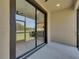Open-air lanai showing a backyard with large windows offering partial views of the kitchen at 4899 Isola Ct, Wesley Chapel, FL 33543