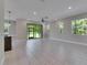 Bright open-concept living area features tile floors, sliding glass doors to backyard, and views of modern kitchen at 4899 Isola Ct, Wesley Chapel, FL 33543