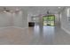 Expansive open-concept living room features tile floors, ceiling fans, and sliding glass doors to the backyard at 4899 Isola Ct, Wesley Chapel, FL 33543