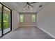 Spacious main bedroom with gray wood floors, recessed lighting, and balcony access at 4899 Isola Ct, Wesley Chapel, FL 33543