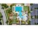 Aerial view showcases the pool area, palm trees, lounge chairs, a slide, and a parking lot at 4899 Isola Ct, Wesley Chapel, FL 33543