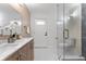 Modern bathroom with a glass door shower, double sinks, and white tile flooring at 8703 Driftwood Dr, Tampa, FL 33615