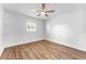 Minimalist bedroom with hardwood floors and ceiling fan, bright and airy at 8703 Driftwood Dr, Tampa, FL 33615