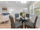 Cozy dining area with a glass-top table, comfortable chairs, and natural light from the nearby windows at 8703 Driftwood Dr, Tampa, FL 33615