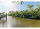 Scenic waterfront view featuring a dock and lush greenery on a sunny day at 8703 Driftwood Dr, Tampa, FL 33615