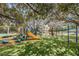 Colorful community playground with slides, climbing structures, and lush greenery for Gathering fun at 1120 Idlewild N Dr, Dunedin, FL 34698