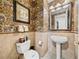Unique half-bathroom with vanity sink, toilet, mirror, towel rack and animal print wallpaper at 12700 Grand Traverse Dr, Dade City, FL 33525