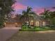 Charming home featuring a barrel tile roof, meticulously manicured landscaping and a three car garage at 12700 Grand Traverse Dr, Dade City, FL 33525