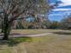 Beautiful golf course view with mature trees, manicured lawns, and a bright blue sky for a relaxing outdoor experience at 12700 Grand Traverse Dr, Dade City, FL 33525