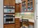Kitchen with desk, oven, and display cabinets with under cabinet lighting, plus tile backsplash at 12700 Grand Traverse Dr, Dade City, FL 33525