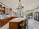 Bright kitchen featuring an island, wood cabinets, stainless appliances, and an adjacent dining nook and living area at 12700 Grand Traverse Dr, Dade City, FL 33525
