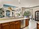 Bright kitchen featuring wood cabinets, stainless appliances, and an adjacent living and dining area at 12700 Grand Traverse Dr, Dade City, FL 33525