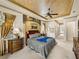 Elegant main bedroom features tray ceiling, luxurious bedding, view of hall and chest of drawers at 12700 Grand Traverse Dr, Dade City, FL 33525