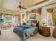 Elegant main bedroom features tray ceiling, luxurious bedding, seating area, and windows at 12700 Grand Traverse Dr, Dade City, FL 33525