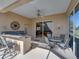 Covered patio with ceiling fan, an outdoor kitchen with a granite countertop, and a dining table with comfortable seating at 12700 Grand Traverse Dr, Dade City, FL 33525