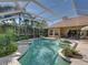 Beautiful screen-enclosed pool and hot tub with lush tropical landscaping creating a backyard paradise for entertainment and relaxation at 12700 Grand Traverse Dr, Dade City, FL 33525