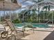 Relaxing screened pool area with lush landscaping and comfortable lounge seating at 12700 Grand Traverse Dr, Dade City, FL 33525