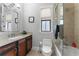 Bright bathroom with dark wood vanity, stone countertop, glass shower, and a window for natural light at 4902 Carranza Ct, Tampa, FL 33616