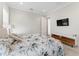 Bedroom featuring a floral comforter, TV, and white entertainment stand with wood accents at 4902 Carranza Ct, Tampa, FL 33616