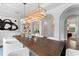 Sophisticated dining room showcasing a long wooden table, elegant chandelier, and arched doorways at 4902 Carranza Ct, Tampa, FL 33616