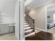 Inviting entryway with wood staircase leading to a bedroom suite and wet bar with white countertops at 4902 Carranza Ct, Tampa, FL 33616