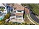 An exterior elevation of a luxury two-story home showing an upper and lower balcony with pool and patio at 4902 Carranza Ct, Tampa, FL 33616