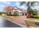 Grand Mediterranean home showcasing its front facade, tile roof, brick driveway and manicured landscaping at 4902 Carranza Ct, Tampa, FL 33616