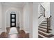 Elegant foyer with decorative front door, hardwood floors, and staircase with wrought iron details at 4902 Carranza Ct, Tampa, FL 33616