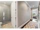 Hallway connecting a full bathroom with walk in shower and a bedroom suite, both decorated in neutral tones at 4902 Carranza Ct, Tampa, FL 33616
