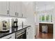 Elegant kitchen bar area featuring custom cabinets, a wine refrigerator, and a sleek countertop at 4902 Carranza Ct, Tampa, FL 33616