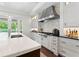 Gourmet kitchen features marble countertops, a stainless steel range hood, and custom cabinetry at 4902 Carranza Ct, Tampa, FL 33616