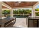 Beautiful outdoor kitchen space with a bar, built-in grill, and a clear view of the sparkling pool and tropical foliage at 4902 Carranza Ct, Tampa, FL 33616