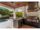 Elegant outdoor kitchen featuring a built-in grill and lush tropical landscaping overlooking the inviting pool at 4902 Carranza Ct, Tampa, FL 33616