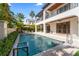 A pristine pool is surrounded by tropical landscaping and overlooks a charming patio seating area at 4902 Carranza Ct, Tampa, FL 33616