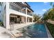 A luxurious backyard featuring a rectangular pool, covered patio, and meticulously manicured landscaping at 4902 Carranza Ct, Tampa, FL 33616